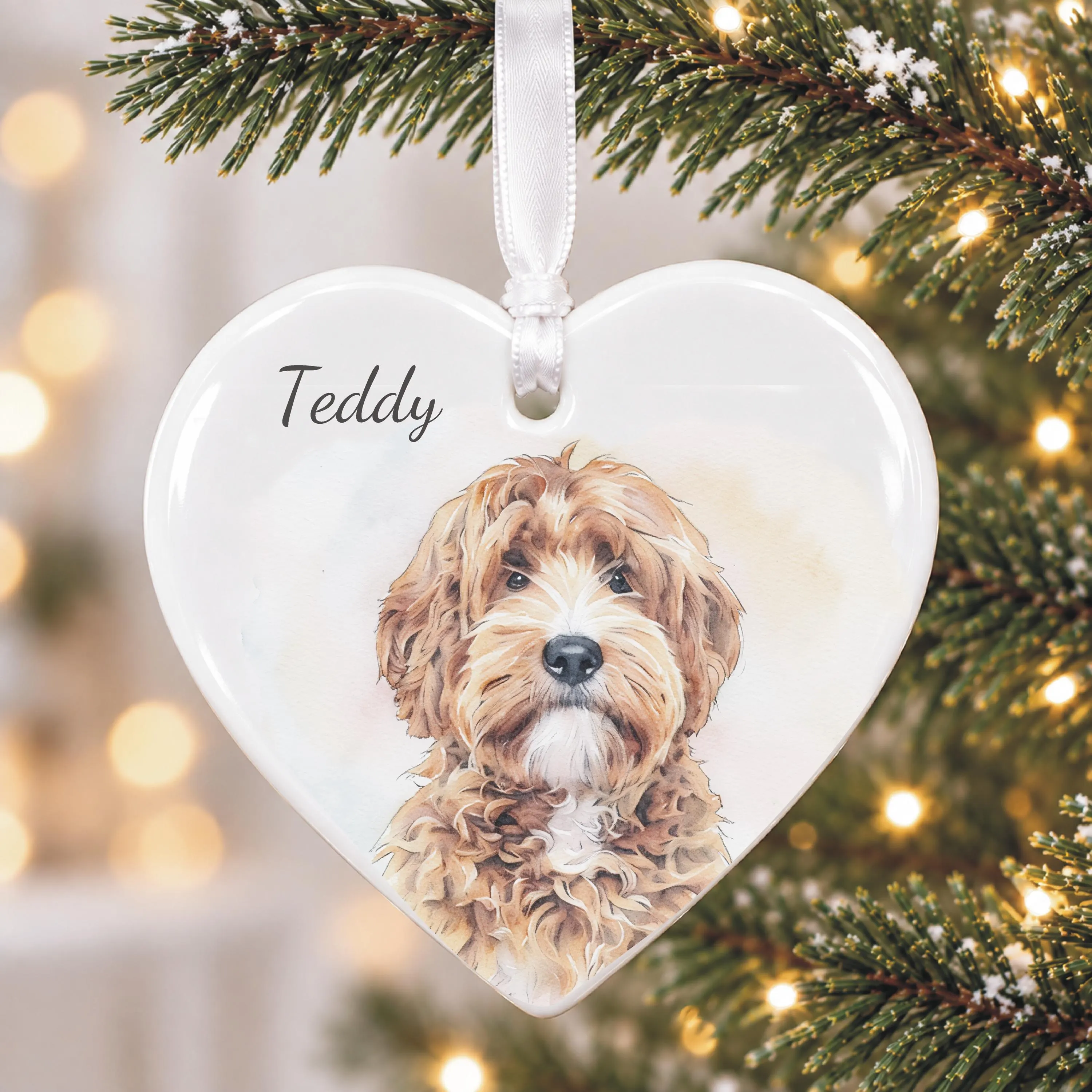 Personalised dog Christmas tree decoration featuring a custom watercolour-style illustration of a pet created from the owner's photograph, displayed on a heart-shaped ceramic ornament with dog's name.