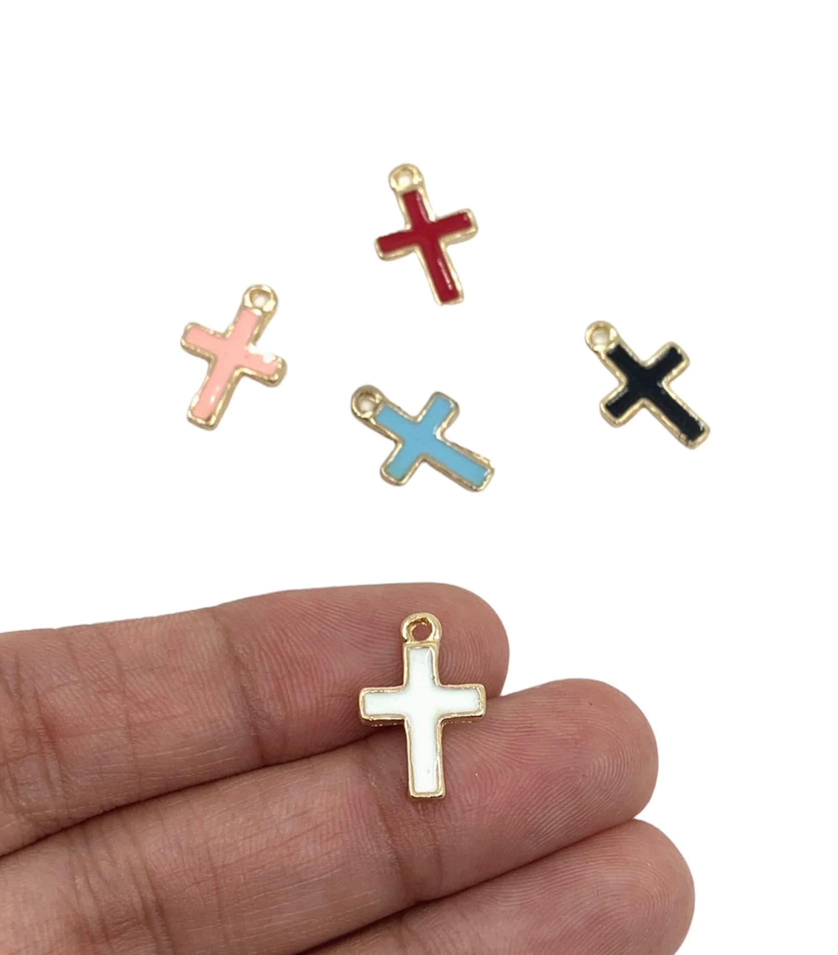 Alloy cross charms on a hand for reference.